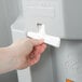 A person using a Koala Kare baby changing station to put tissue paper in the dispenser.