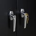 The door lock on a black HON Brigade storage cabinet with a pair of keys inside.