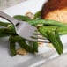 A Bon Chef Milan dinner fork on a plate of green beans and meat.