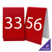 Two red Cal-Mil customizable table number tent signs with white numbers.