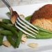 A Bon Chef stainless steel dinner fork on a plate with food.