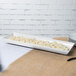A white rectangular Tablecraft tray with food in it.