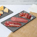 A Tablecraft granite cast aluminum rectangular cooling platter with meat and cheese.