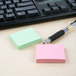 Redi-Tag assorted color self-stick notes and a pen on a desk.