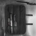 A Dexter-Russell black cutlery roll with a knife and two cases.