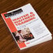 A book titled "Waiter & Waitress Training" on a table in a professional kitchen.