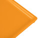 An orange cast aluminum Tablecraft rectangular cooling platter on a yellow surface.