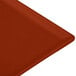 A Tablecraft copper cast aluminum rectangular cooling platter on a red surface.