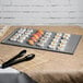 A Tablecraft granite cast aluminum rectangular cooling platter on a table with sushi on it.