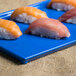 Blue speckled cast aluminum rectangular cooling platter with sushi on it.