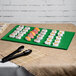 A Tablecraft green cast aluminum rectangular cooling platter on a table with sushi on it.