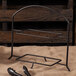 A black metal Clipper Mill table riser with shelves on a burlap surface.