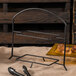 A black metal Clipper Mill 2 tier table riser with food on plates.
