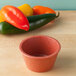 A close-up of a red HS Inc. paprika ramekin.