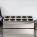 A Steril-Sil stainless steel countertop flatware organizer with 10 cylinders with holes in it.