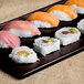 A Tablecraft midnight speckle cast aluminum rectangular cooling platter holding sushi.