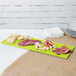 A lime green rectangular Tablecraft cast aluminum tray with meat and cheese on it.