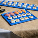 A blue Tablecraft rectangular cast aluminum cooling platter with sushi on it.