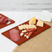 A Tablecraft copper cast aluminum rectangular cooling platter with meat and cheese on a table.