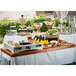 A Translucent copper Tablecraft metal table cover on a table with food on it.