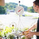 A man weighing fruit on a Cardinal Detecto hanging scale.