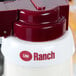 A white plastic Tablecraft salad dressing dispenser collar with maroon lettering and a red lid.