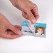 A person's hands using a Fellowes ID badge laminating pouch to protect an ID card.