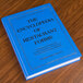 The Encyclopedia of Restaurant Forms book on a wood counter.