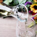 A person using a Stolzle Pisa carafe to pour wine into a glass.