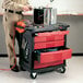 A man working on a Rubbermaid mobile work center with 5 drawers filled with tools.