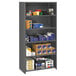 A Tennsco medium gray commercial steel shelving unit with five shelves holding boxes and papers.