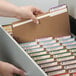 A person taking a file out of a drawer using a Smead Letter Size Fastener Folder.