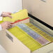 A person using Smead yellow letter size folders to open a file cabinet.