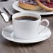 A Schonwald white porcelain saucer with a cup of coffee on it.