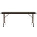A Correll walnut folding table with black legs and a black top.