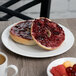 A Schonwald white porcelain plate with a bagel and jam next to a cup of coffee.