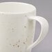 A close up of a white Schonwald porcelain mug with a speckled design.