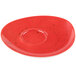 A red porcelain saucer with specks on it.