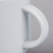 A close up of a white Schonwald stacking mug with a handle.