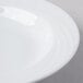 A close up of a Schonwald white porcelain bowl with a curved edge.