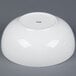 A bright white porcelain salad bowl with a small hole in the middle.