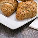 A Schonwald rectangular white porcelain platter with three croissants on it.