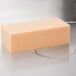 An orange rectangular Unger sponge on a white surface.
