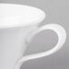 A close-up of a Schonwald white porcelain cup with a handle.