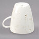 A white Schonwald porcelain cup with brown specks on it.