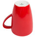 A red Schonwald porcelain mug with a white handle.