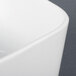 A close-up of a CAC white square sauce cup.