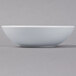 A Schonwald round white porcelain bowl on a white surface.