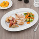 A Schonwald white porcelain platter with chicken, potatoes, and carrots on a table.