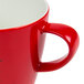 A close-up of a Schonwald red porcelain cup with a speckled design.
